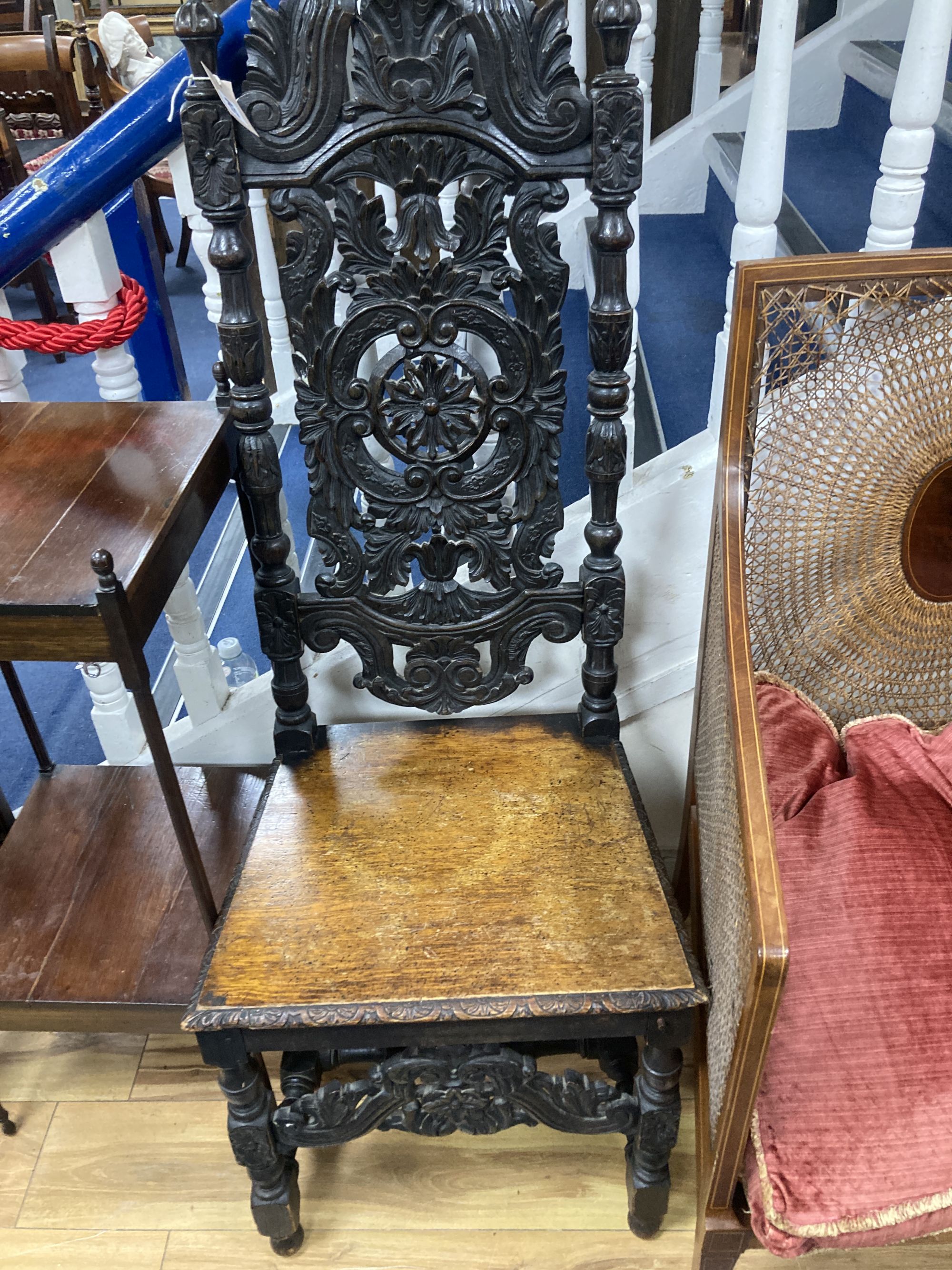 A Flemish carved oak dining chair and an Edwardian bergere chair